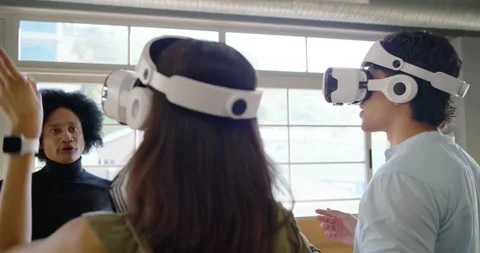 Diverse team trying VR sets in studio woman stepping donning headset, guide Stock Footage 337944594