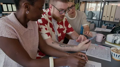 Diverse Team of UI Designers Testing Mobile App on Phone at Office Desk Stock Footage 313932517