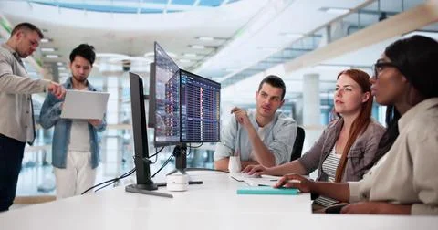 Diverse Team Utilizes Multiple Computers For Medical Billing Audit Task. Foto stock