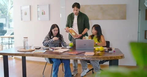 Diverse team working at wooden table man showing folder women sorting papers on Stock Footage 335212449
