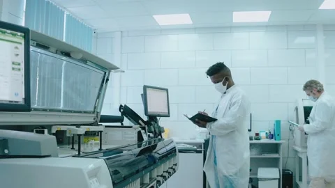 A diverse team works in the lab using tablet computers, wearing masks and gowns 스톡 동영상 166664246