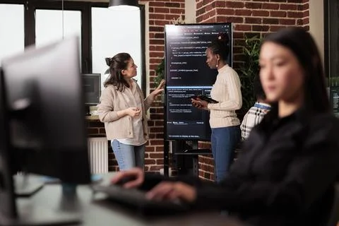 Diverse tech enginners talking about algorithms Foto stock