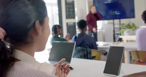 Diverse teens clapping then watching maroon-clad presenter finishing coding on Stock Footage 341063485
