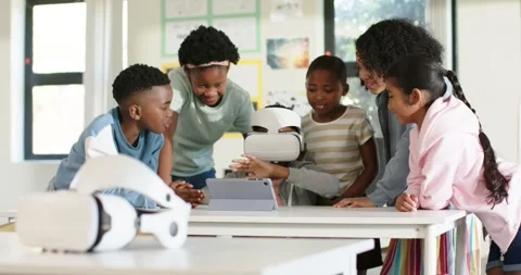 Diverse teens crowding white headset on school table, watching teen exploring VR Stock Footage 341851903