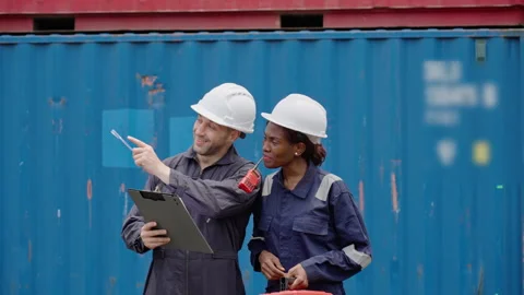 Diverse Two Logistics Workers in Hard Hats Inspecting Shipping Stacked Cont.. Stock Footage 335875219