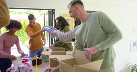 Diverse volunteers sorting and packing donation boxes as they passing basketball Stock Footage 338325605