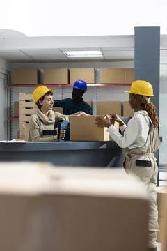 Diverse warehouse team using bar code scanners to manage packages Photos
