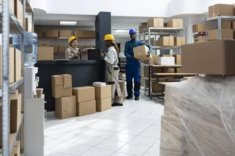 Diverse warehouse team using bar code scanners to manage packages Photos
