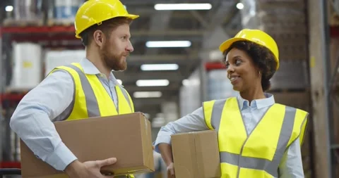 Diverse warehouse workers with cardboard boxes standing near aisle and talking Stock Footage 151400964