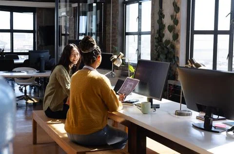 Diverse women collaborating on coding project in modern office, sharing ideas Stock-Fotos