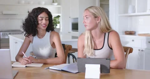 Diverse women collaborating at table in kitchen right woman proposing center Stock Footage 341933176