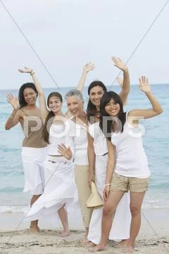 Diverse Women Standing On Beach Together Waving