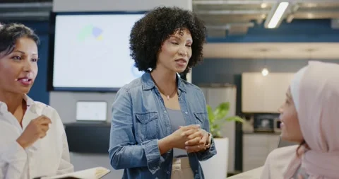 Diverse women taking notes after speaker in denim shirt standing, explaining Stock Footage 345766110