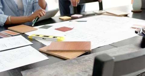 Diverse women using tablet while viewing plans, mentor pointing samples in Stock Footage 334843264