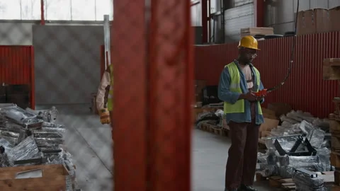 Diverse Workers Operating Crane and Pulling Trolley at Factory Warehouse Stock Footage 300136845