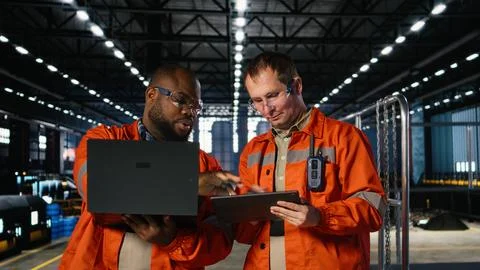 Diverse workers using devices to manage steel production tasks Stock Photos