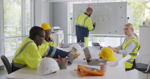 Diverse young architects working on new project with male contractor in office Stock Footage 156187665