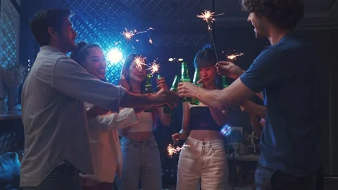 Diverse  young people clinking beer and waving sparkler on night party Video stock 166475231