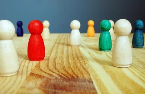 Diversity concept. Colored figures between wooden ones. Stock Photos