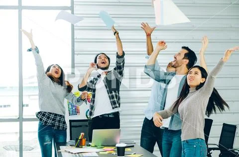 Diversity Designer in casual cloth throw paper up in the air for success proj Stock Photos