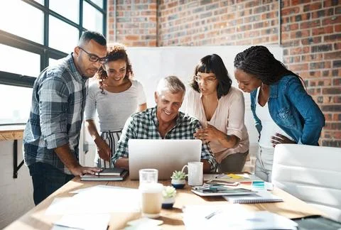 Diversity, group of colleagues and using a laptop together or collaborating on a Stock Photos