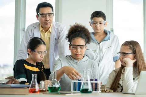 Diversity group of students in science class doing chemical experiment in l.. Stock Photos