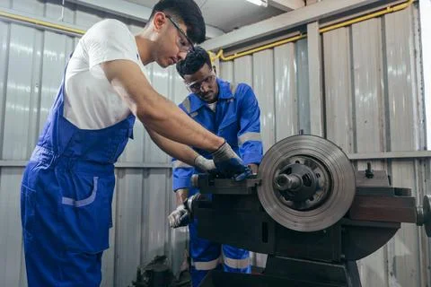 Diversity mechanic worker using metal lathe machine repairing at auto repai.. Stock Photos