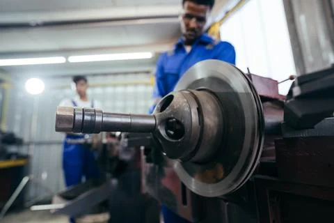 Diversity mechanic worker using metal lathe machine repairing at auto repai.. Stock Photos
