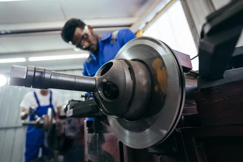Diversity mechanic worker using metal lathe machine repairing at auto repai.. Stock Photos