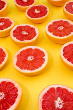 Divided Grapefruit on a yellow background Stock Photos