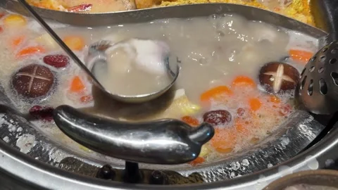 Divided Hot Pot Simmering with Meat and fish slices, Mushrooms and Carrots Видео 346714448