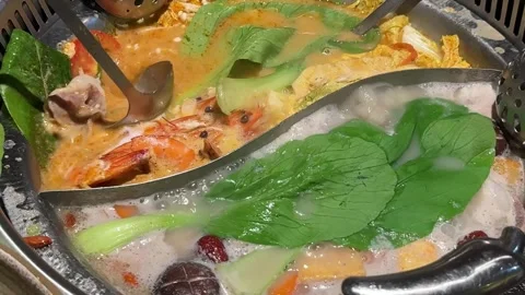 Divided Hot Pot Simmering with Shrimp and Vegetables Stock Footage 346618350