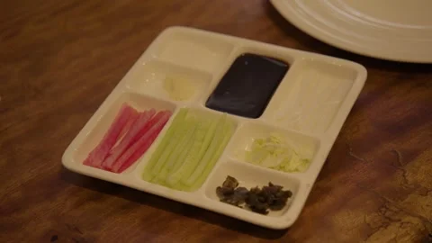Divided Plate of Condiments and Sliced Vegetables on Restaurant Table in Beijing Stock Footage 345762262