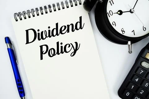 Dividend Policy text written on notepad with calculator and alarm clock Stock Photos