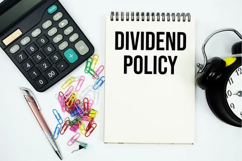 Dividend Yield text written on notepad with calculator and alarm clock Stock Photos