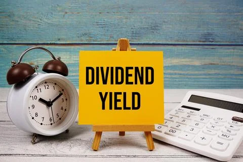 Dividend Yield text written on paper card with calculator and alarm clock o.. Stock Photos