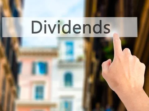Dividends - Hand pressing a button on blurred background concept on visual sc Stock-Fotos