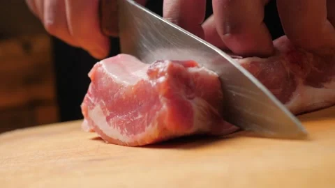 Divides raw pork ribs with a knife on a wooden board. Stock-Footage 210773965