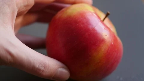 Dividing apple on two parts with hands on a grey background Stock Footage 88771289