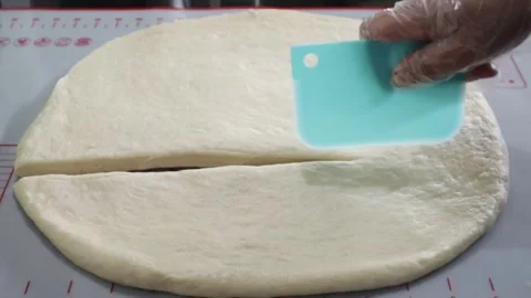 Dividing flat dough by hands and cutter  Stock Footage 158230656