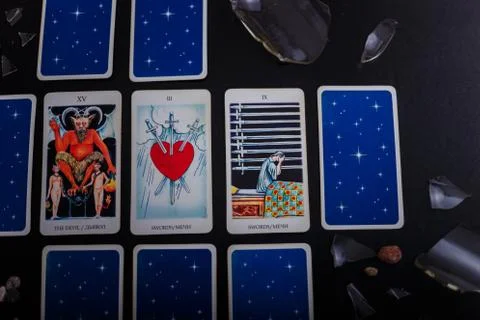 Divination cards alignment. Devil and swords. Background with broken glass Stock Photos