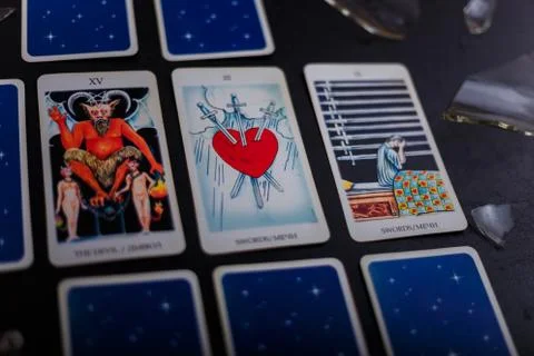Divination cards alignment. Devil and swords. Background with broken glass Foto stock