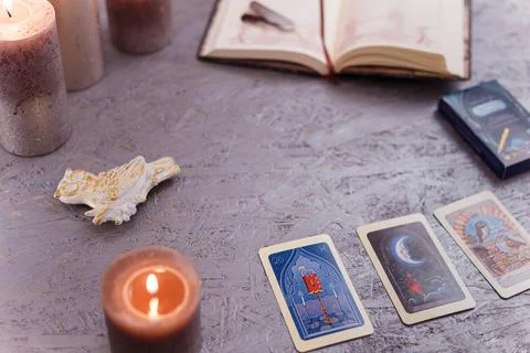 Divination cards alignment with feathers and candles on silver background Stock Photos