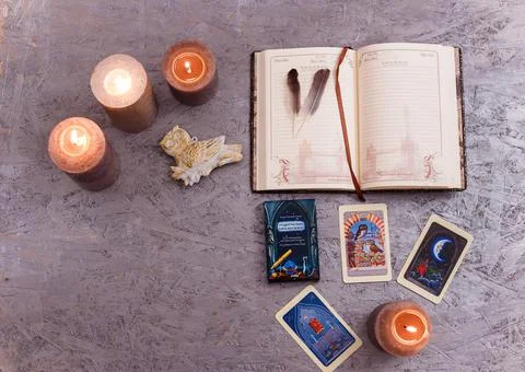 Divination cards alignment with feathers and candles on silver background Stock Photos