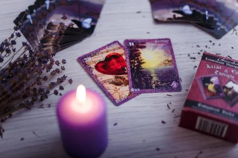 Divination cards alignment with purple burning candle and dry lavender. Stock Photos
