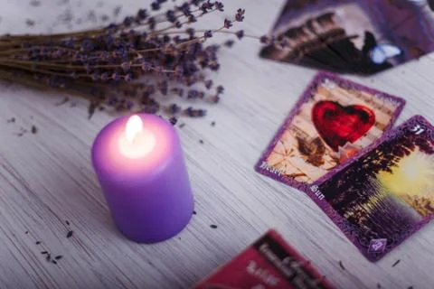 Divination cards alignment with purple burning candle and dry lavender. Foto stock
