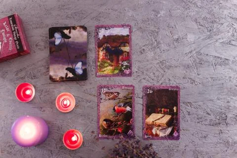 Divination cards alignment with purple burning candle and dry lavender. Stock Photos