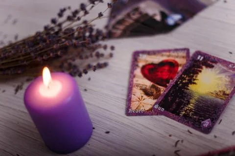 Divination cards alignment with purple burning candle and dry lavender. Foto stock