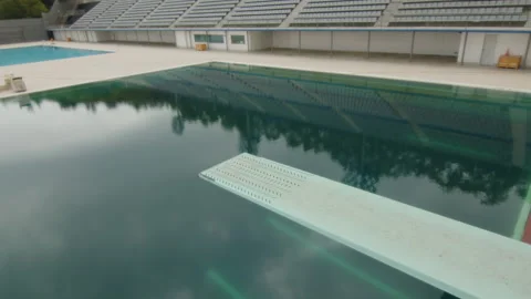 Diving above a large Olympic pool on a cloudy day, in Barcelona, Spain Stock Footage 221113600