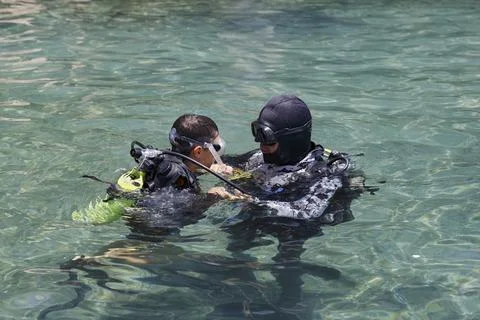 Diving with aqualung lesson, instructor giving scuba diving lessons to a kid. Foto stock